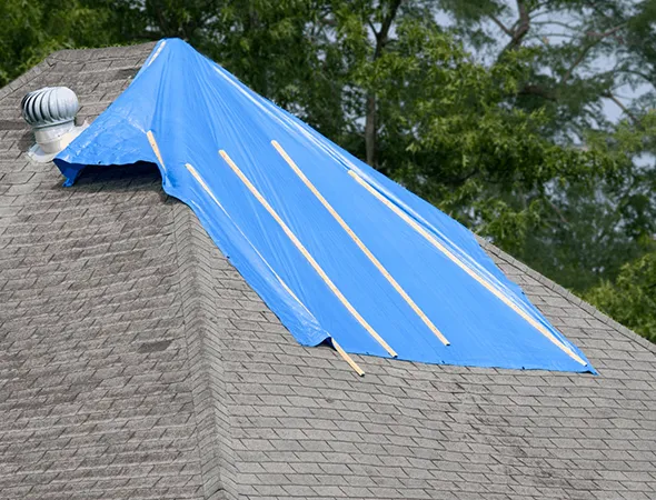 Blue tarp covering a roof for storm protection, highlighting benefits of emergency board-up services in Rancho Mirage, CA.