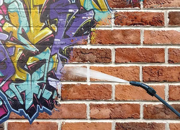 Close-up of colorful graffiti art on a brick wall illustrating the need for removal services.