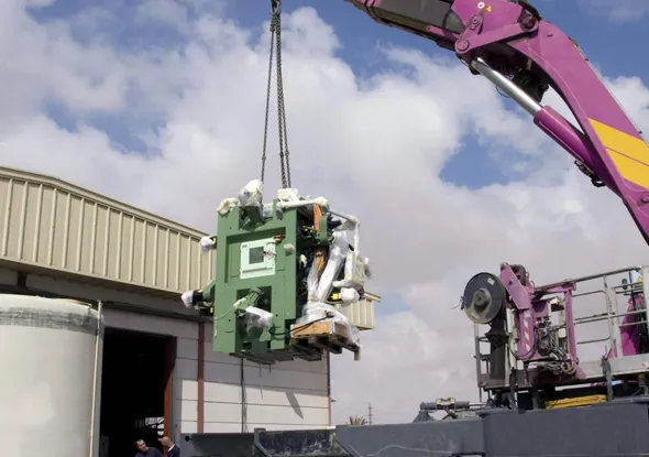 Industrial equipment being installed by a crane under a blue sky, showcasing reliable equipment replacement services in Palm Desert, CA.